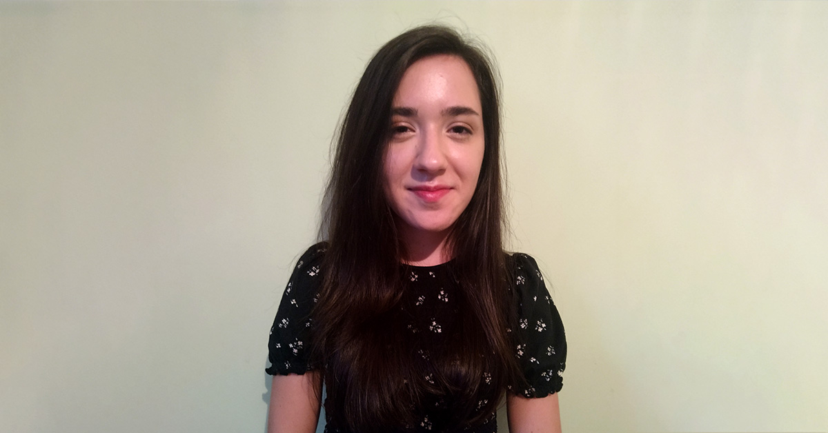 Picture of a girl (Telerik Academy alumni) in front of a wall in a bright colour